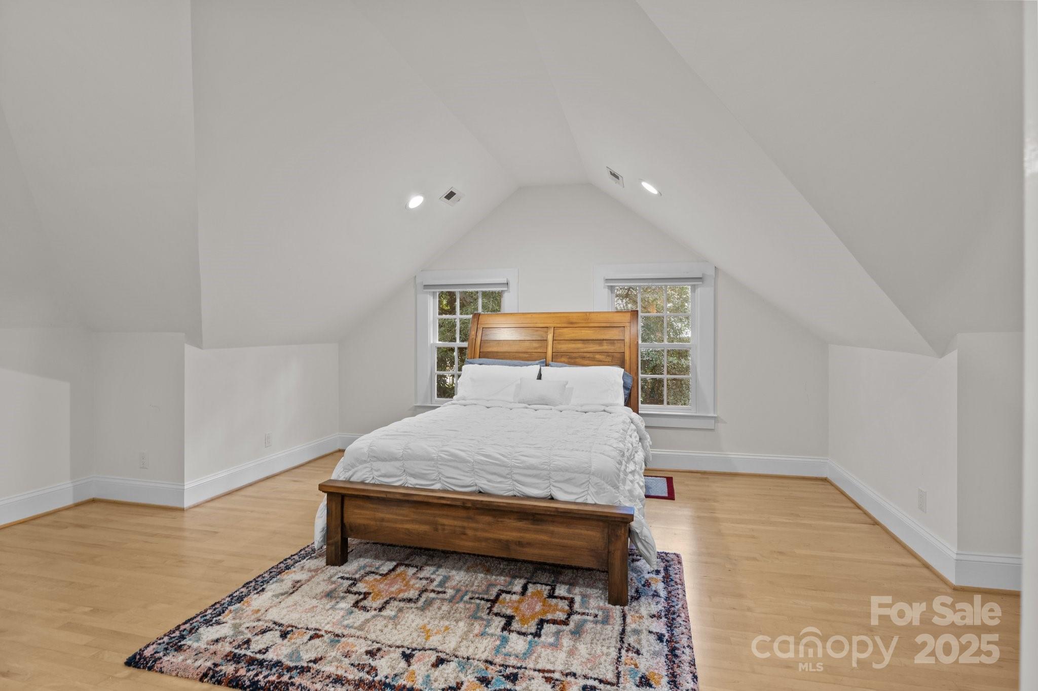 560 Concord Road Davidson, NC 28036 - Photo 31 of 34 a bedroom with a bed and wooden floor