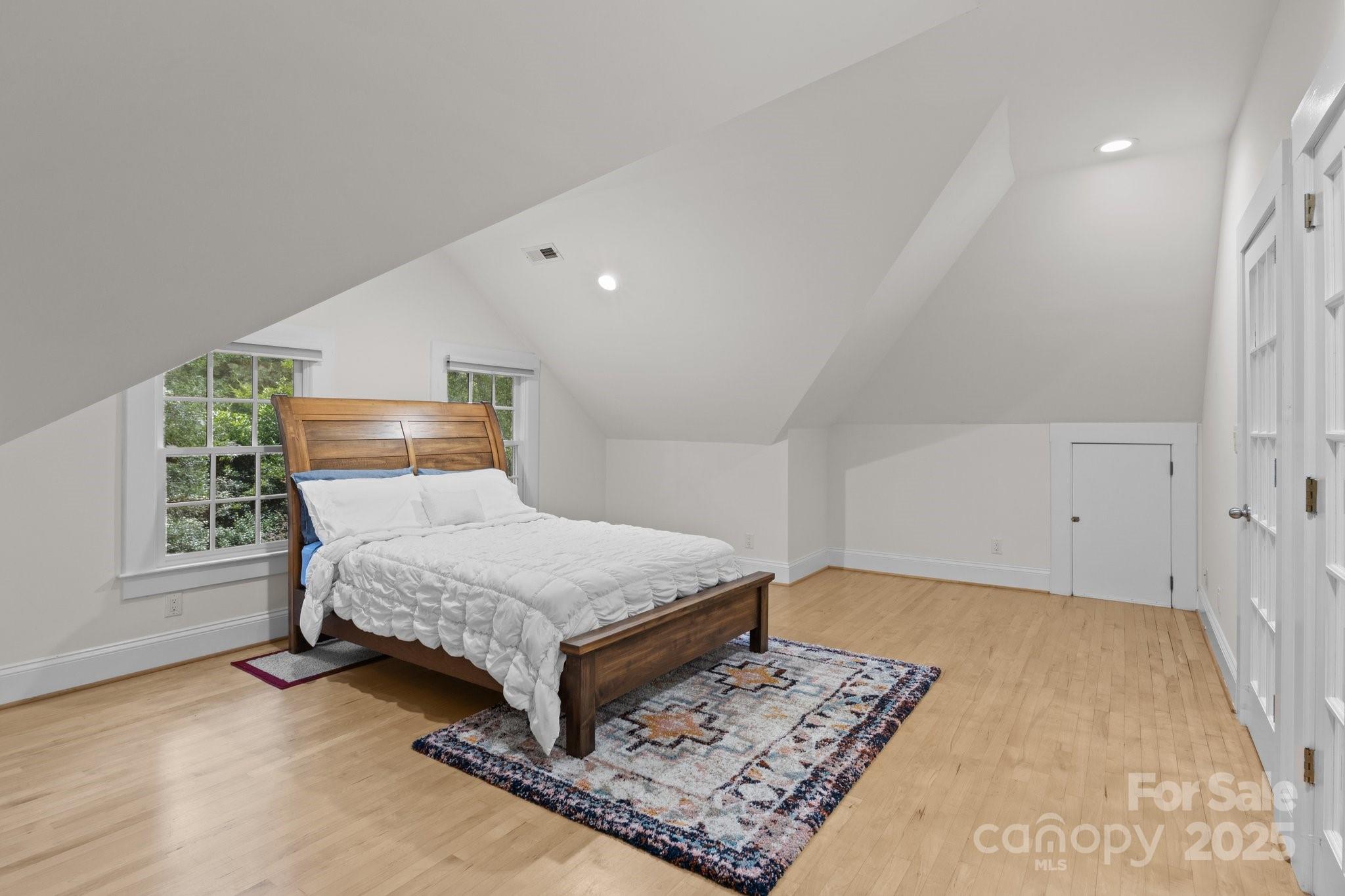 560 Concord Road Davidson, NC 28036 - Photo 32 of 34 a bedroom with a bed rug and wooden floor