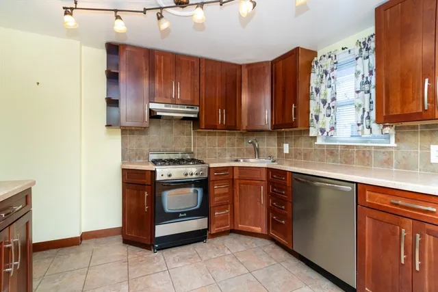 a kitchen with stainless steel appliances granite countertop wooden cabinets a sink and dishwasher