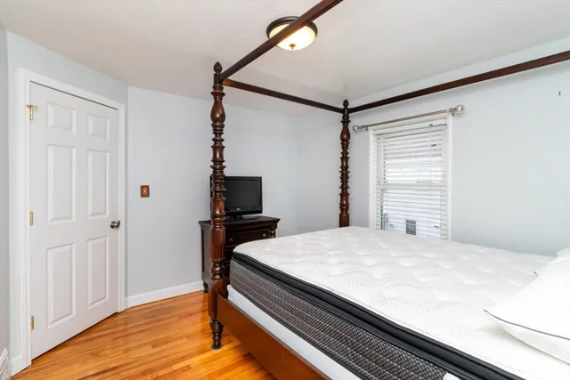 a bedroom with a bed and a flat tv screen on a dresser