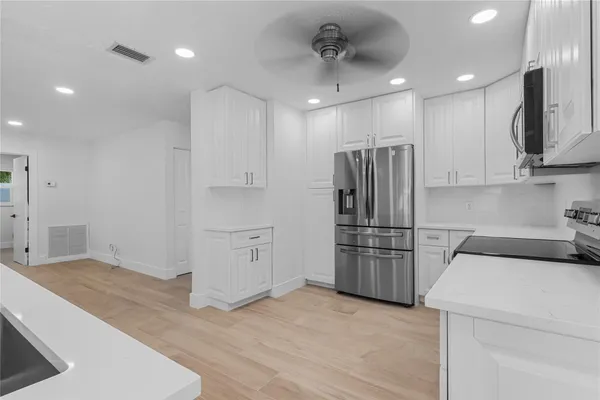 a kitchen with white cabinets and stainless steel appliances