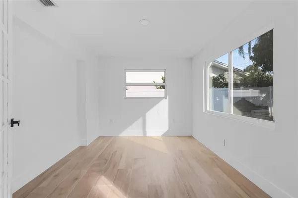 wooden floor in an empty room with a bathroom