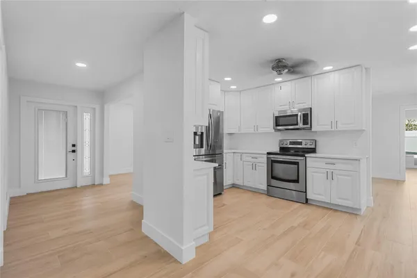 a kitchen with granite countertop a refrigerator stove and sink