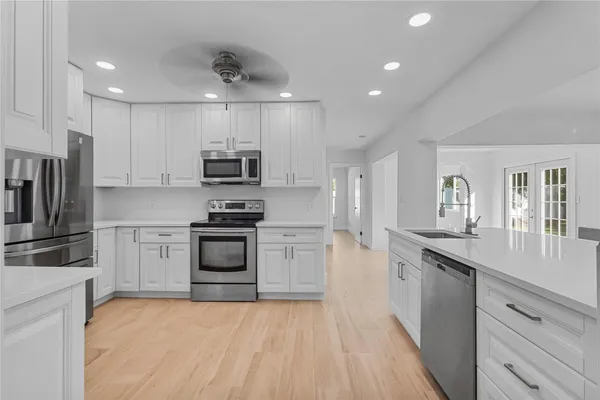 a kitchen with stainless steel appliances a refrigerator and a stove top oven