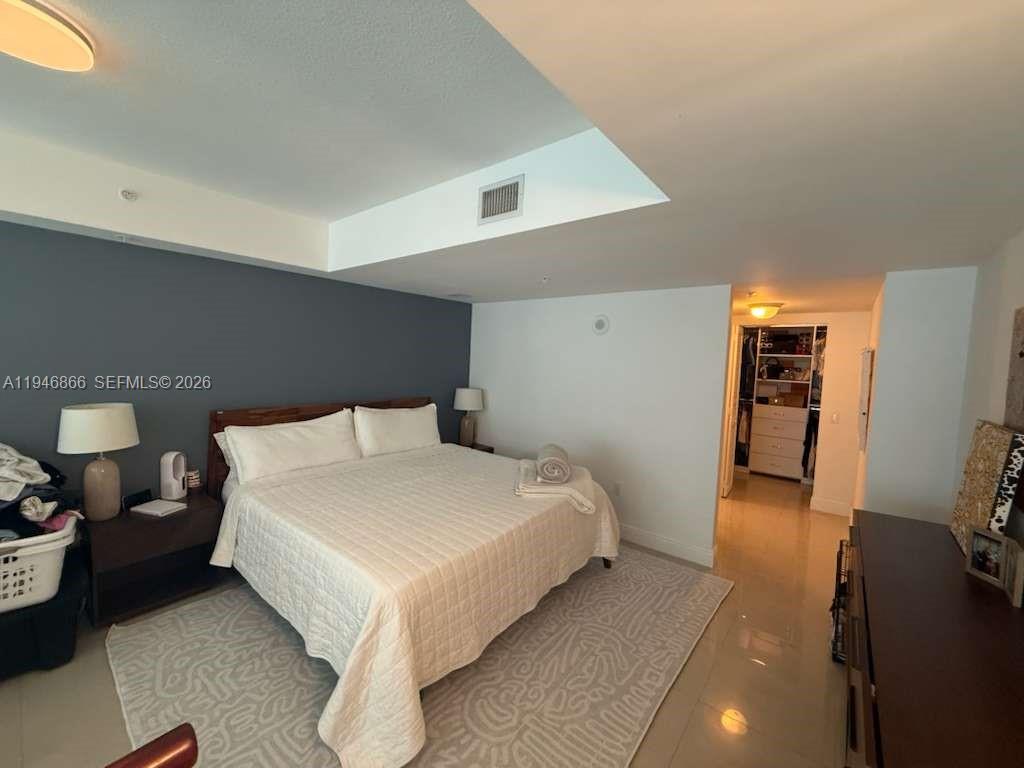 41 Southeast 5th Street, Unit 912 Miami, FL 33131 - Photo 13 of 23 a bedroom with a bed and a walk in closet