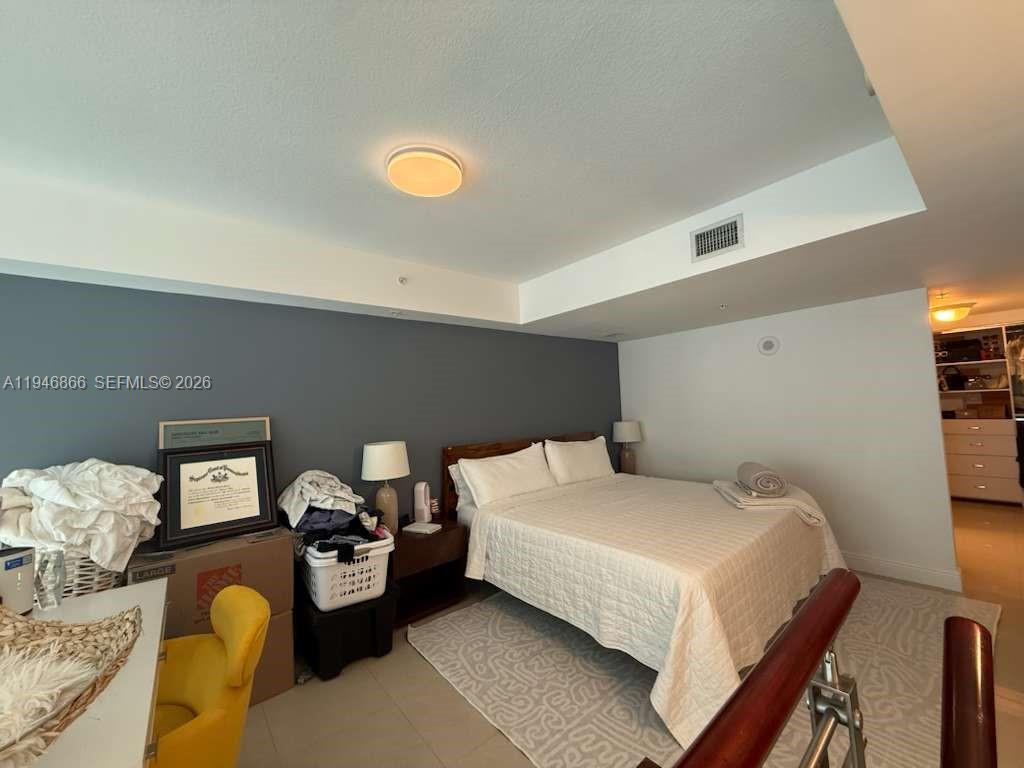 41 Southeast 5th Street, Unit 912 Miami, FL 33131 - Photo 14 of 23 a bedroom with a bed and couch