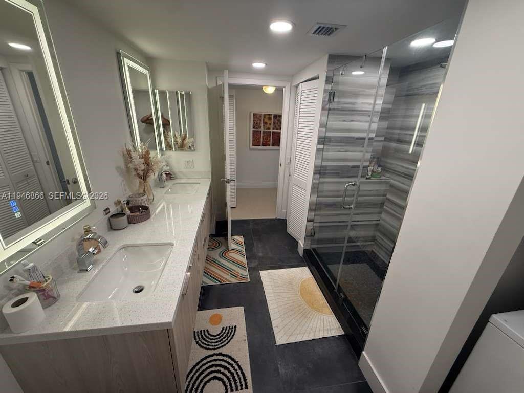 41 Southeast 5th Street, Unit 912 Miami, FL 33131 - Photo 16 of 23 a bathroom with double vanity and a bathtub