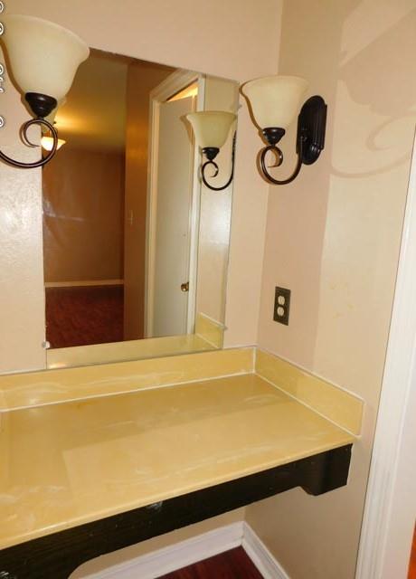 8020 Pines Road Shreveport, LA 71129 - Photo 18 of 24 Marble vanity area with decorative sconces and mirror in the front master primary bedroom.