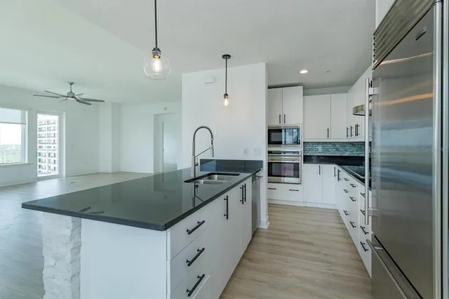a kitchen with granite countertop a sink stove and refrigerator