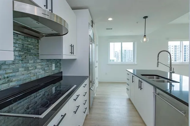 a kitchen with granite countertop a sink stove and cabinets