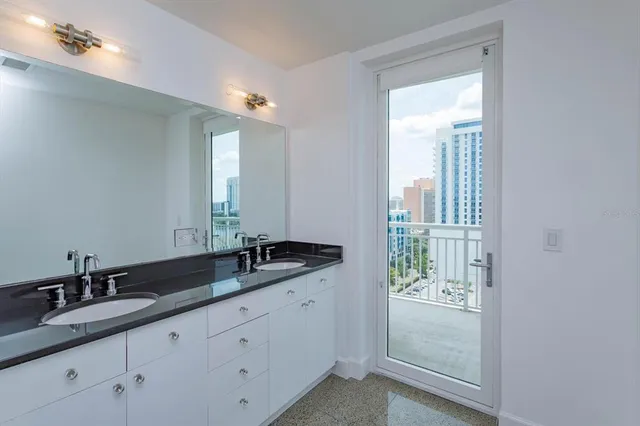a bathroom with a granite countertop sink and a mirror