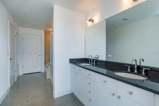 a bathroom with double sink and a mirror