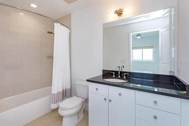 a bathroom with a granite countertop sink a toilet and a bathtub