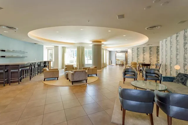 a living room with lots of furniture and a view of kitchen