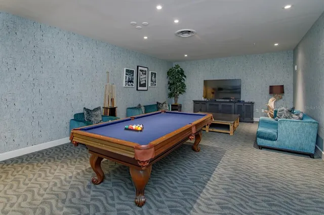 a room with furniture pool table flat screen tv and a couch