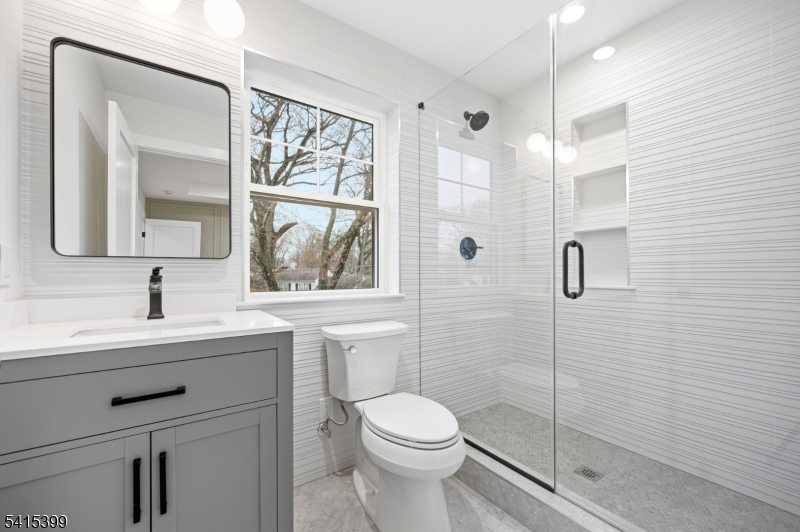 41 Orchard Road Florham Park, NJ 07932 - Photo 21 of 34 a bathroom with a toilet a sink a glass door a shower and a mirror
