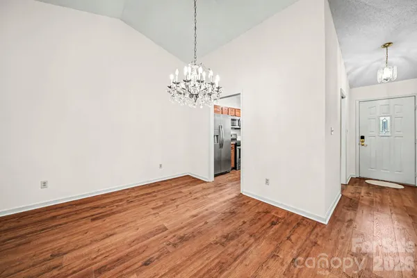 a view of a room with wooden floor and chandelier