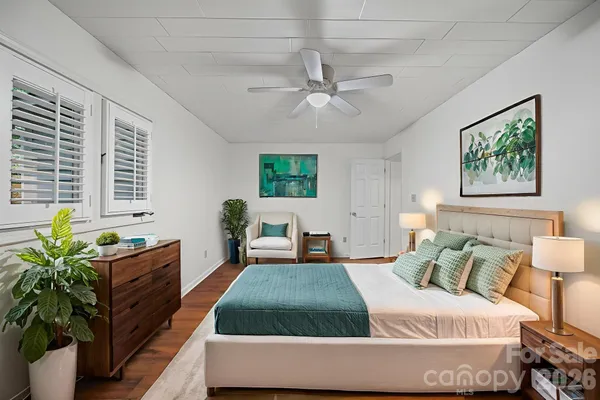 a bedroom with a bed and a potted plant