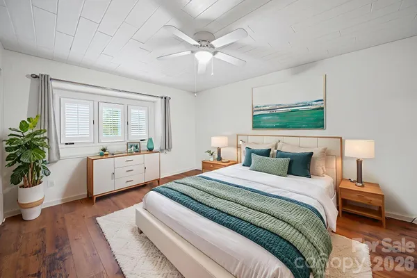 a bedroom with a large bed and a chandelier