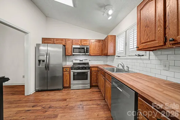 a kitchen with stainless steel appliances granite countertop a refrigerator stove and sink