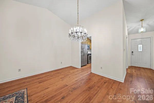 a view of a room with wooden floor and chandelier