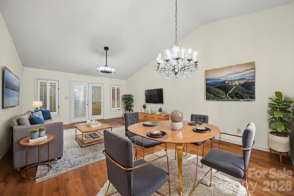 a dining room with furniture a chandelier and wooden floor