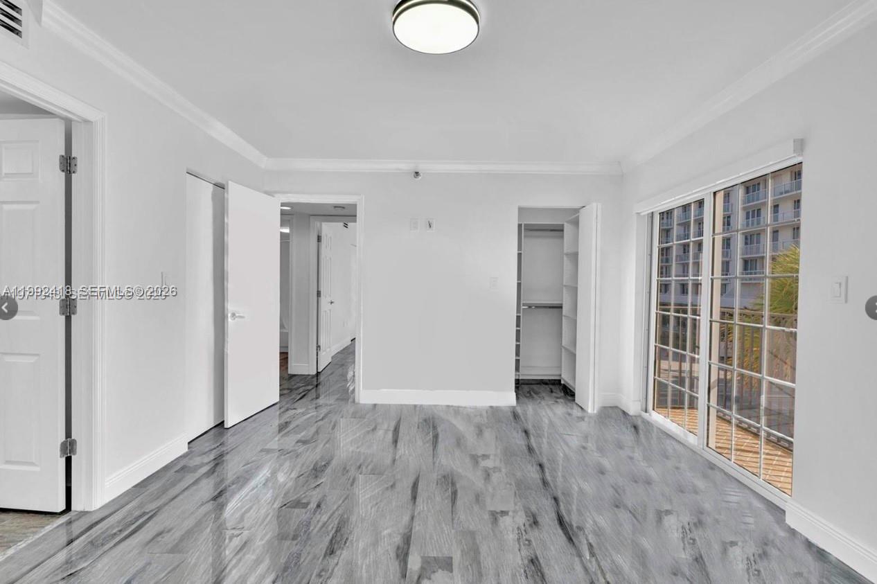 8900 Collins Avenue, Unit 304 Surfside, FL 33154 - Photo 5 of 18 a view of empty room with wooden floor and window