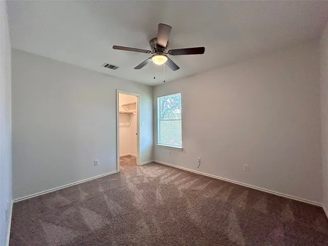 an empty room with closet and windows