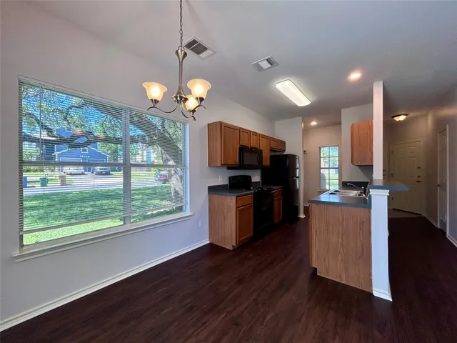 a view of kitchen with microwave stove refrigerator and wooden floor
