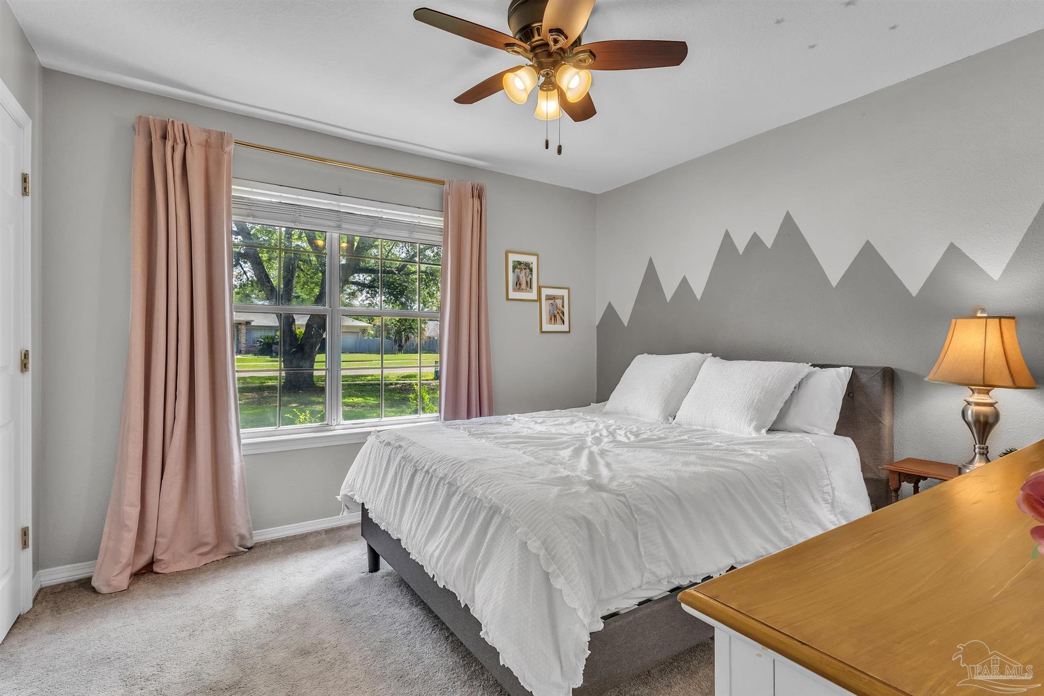 4321 Ridgeland Drive Pace, FL 32571 - Photo 19 of 36 a bedroom with a bed and a chandelier