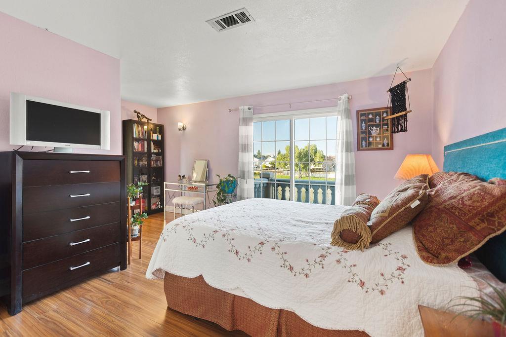 35664 Lundy Drive Newark, CA 94560 - Photo 20 of 34 a bedroom with a bed and a flat tv screen on dresser