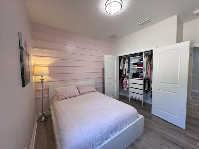 a bedroom with a bed and wooden floor
