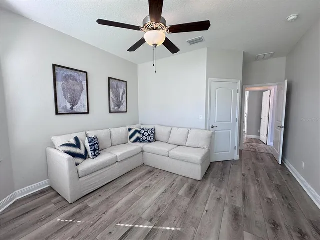 a living room with couches and a coffee table with wooden floor