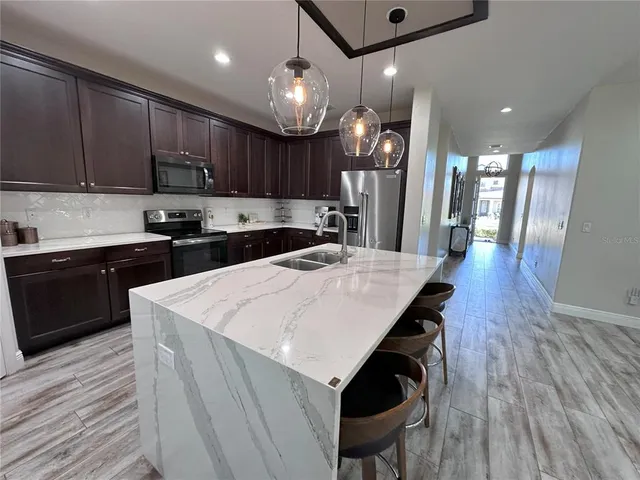 a kitchen with a sink a microwave and wooden cabinets