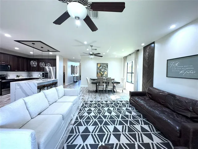 a living room with furniture and kitchen view