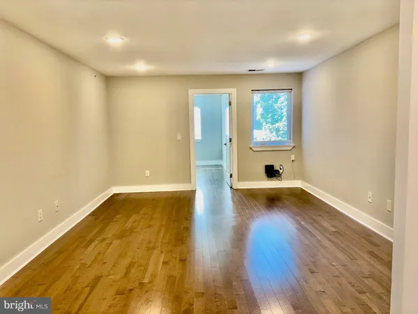 a view of empty room with wooden floor