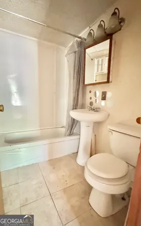 a bathroom with a toilet a sink and bathtub