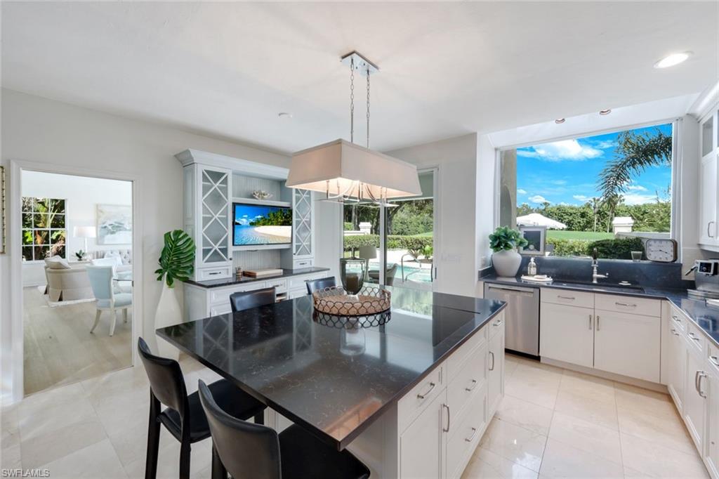 211 Via Napoli Naples, FL 34105 - Photo 13 of 50 a kitchen with a table and chairs in it