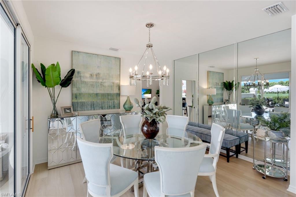 211 Via Napoli Naples, FL 34105 - Photo 18 of 50 a view of a dining room with furniture wooden floor and chandelier