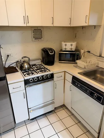a white stove top oven sitting inside of a kitchen
