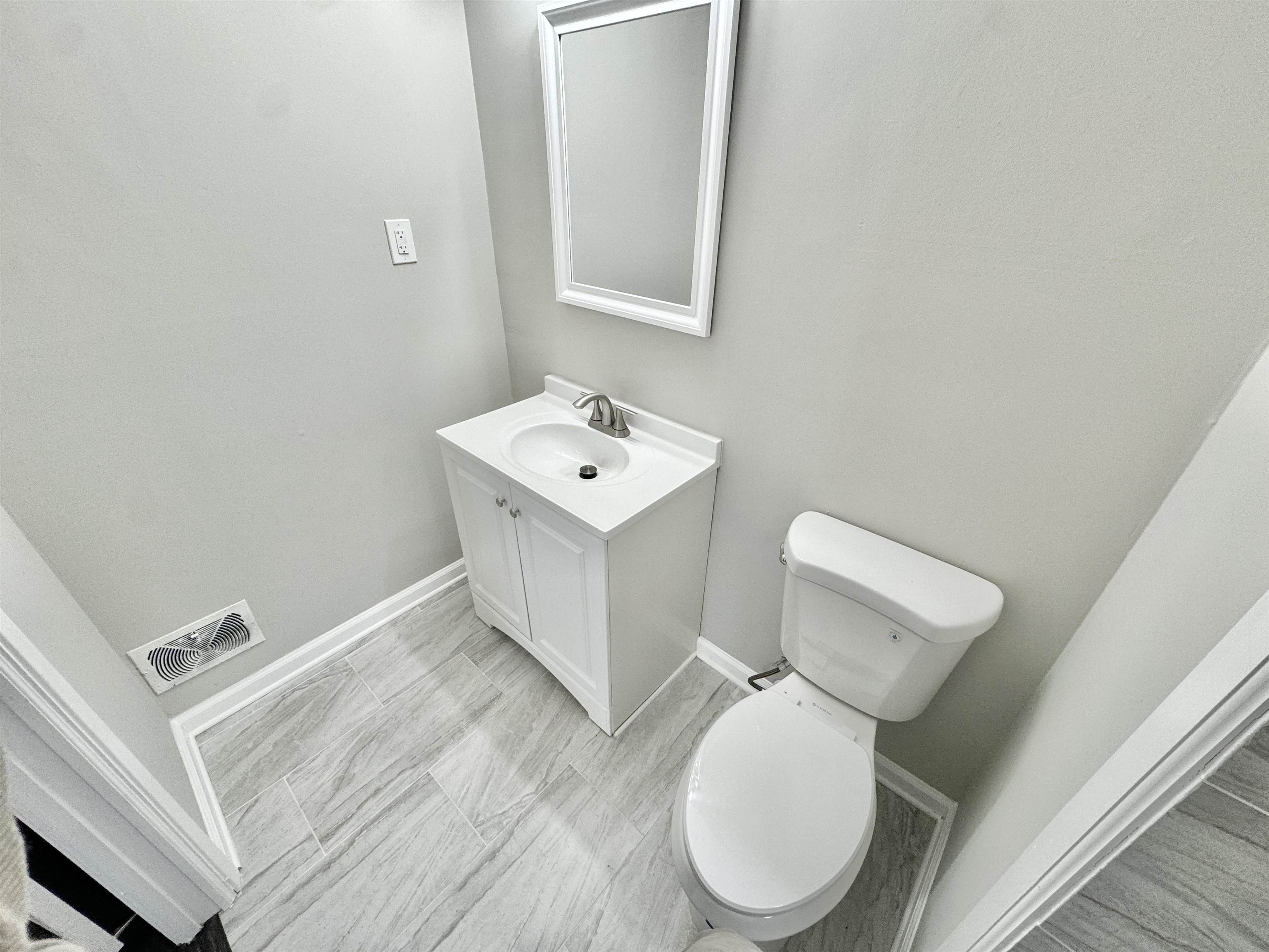 2009 West Holmes Road Memphis, TN 38109 - Photo 14 of 28 Bathroom featuring toilet, vanity, visible vents, and baseboards