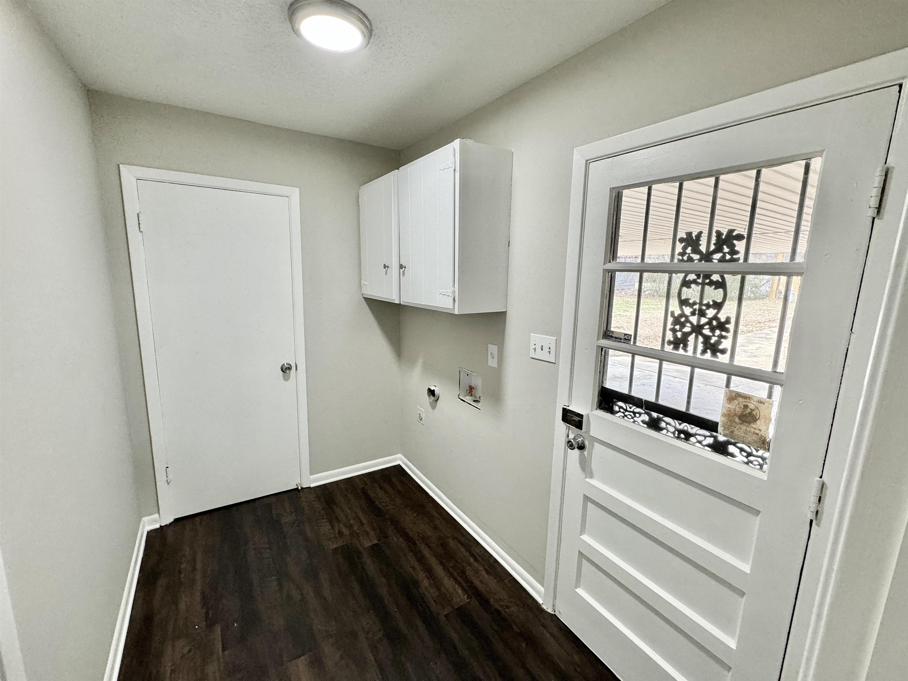 2009 West Holmes Road Memphis, TN 38109 - Photo 23 of 28 Clothes washing area with dark wood-type flooring, washer hookup, cabinet space, and baseboards