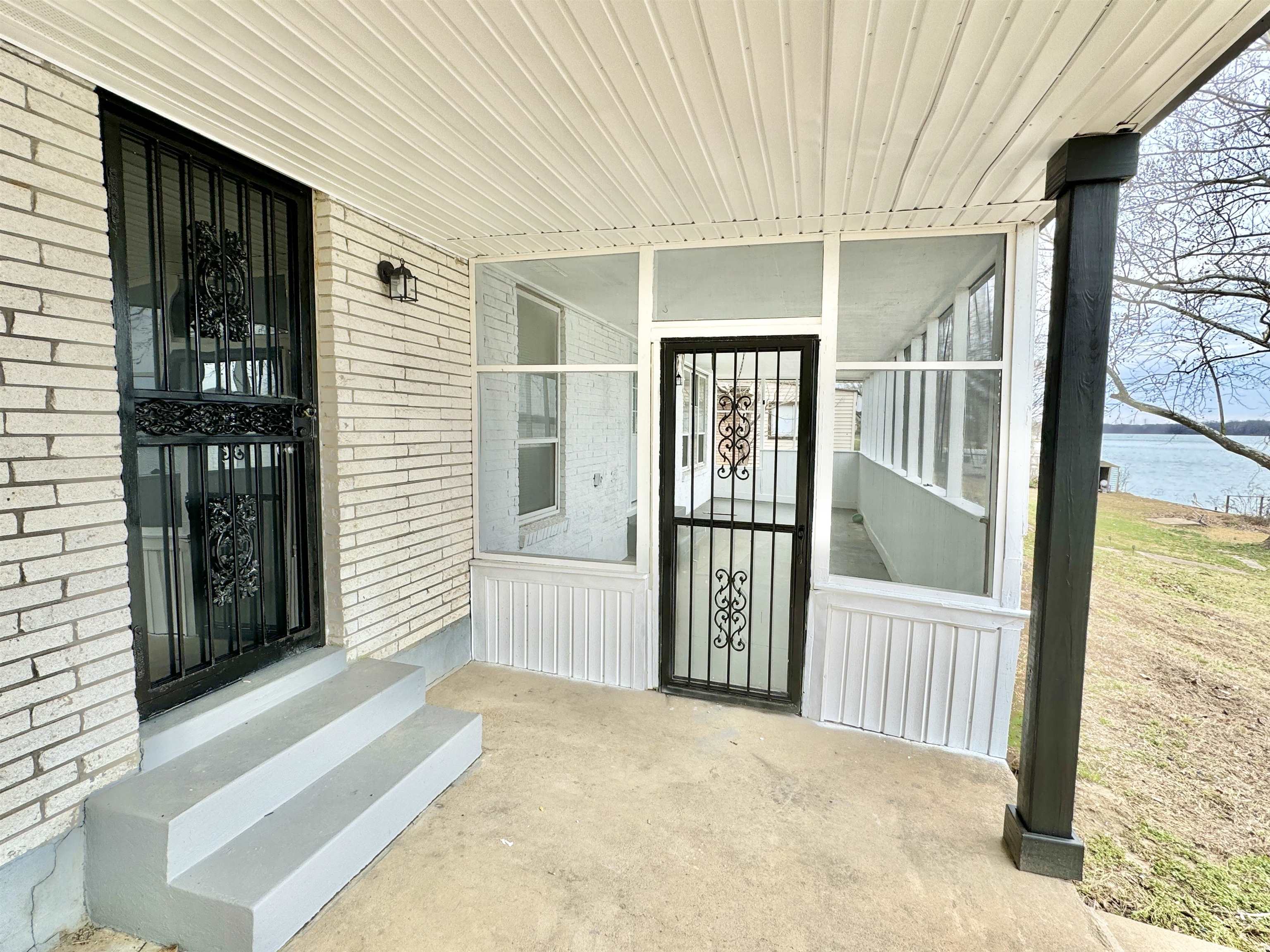 View of exterior entry with brick siding and a water view
