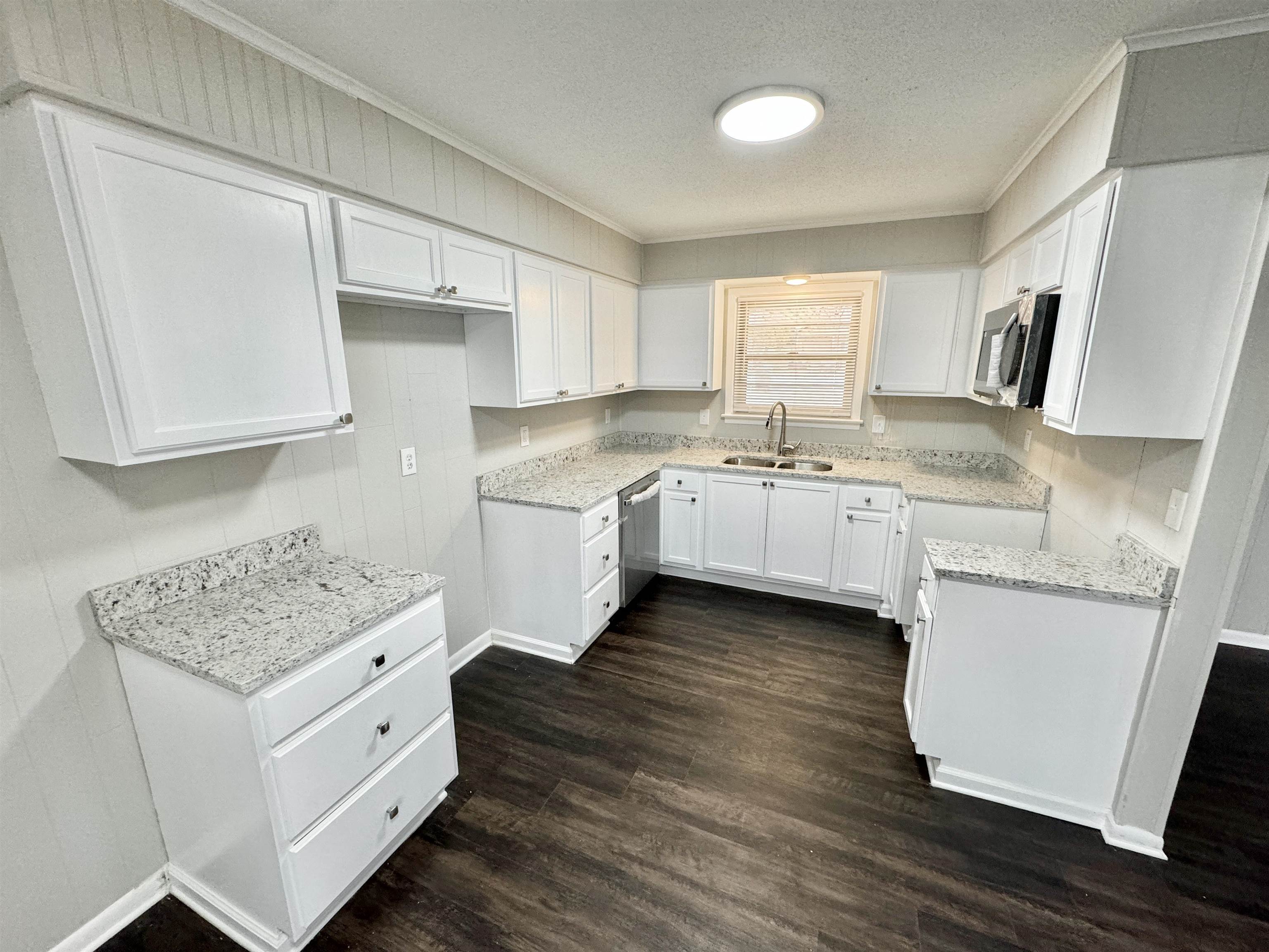 2009 West Holmes Road Memphis, TN 38109 - Photo 10 of 28 Kitchen with dark wood-style flooring, appliances with stainless steel finishes, white cabinetry, a sink, and a textured ceiling