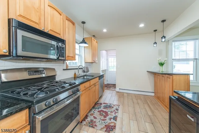 a kitchen with stainless steel appliances granite countertop a stove a sink and a microwave