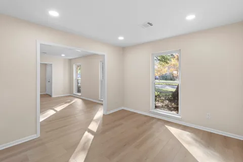 an empty room with wooden floor and bathroom