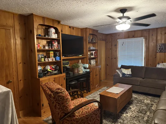 a living room with furniture a ceiling fan and a window