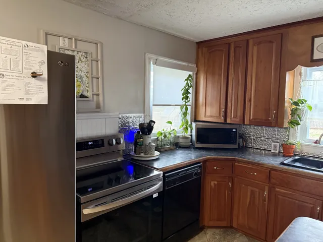 a kitchen with granite countertop a sink stove and cabinets