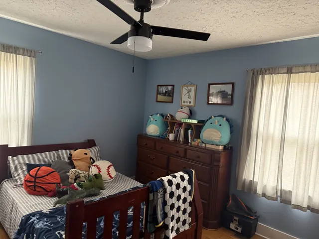 a bedroom with a bed and wooden floor