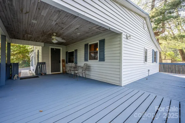 a view of a deck with wooden floor and roof with a chair